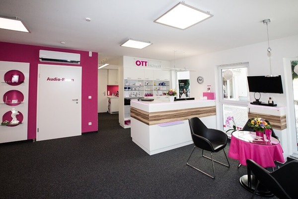 Modernes Hörakustik-Fachgeschäft mit Empfangstresen, Wartebereich und Beratungsecke.